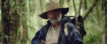 Movie still from “Hunt for the Wilderpeople” (2016), directed by Taika Waititi – An older man with a beard and a hat; Close Up shot, Over the shoulder angle