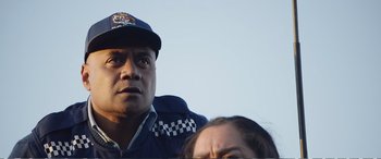 Movie still from “Hunt for the Wilderpeople” (2016), directed by Taika Waititi – A man and a woman wearing a police uniform; Close Up shot, Low angle