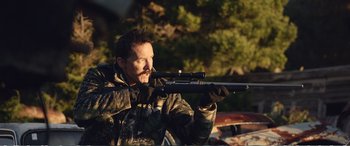 Movie still from “Hunt for the Wilderpeople” (2016), directed by Taika Waititi – A man with a rifle in a forest; Medium shot, Over the shoulder angle