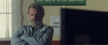 Movie still from “Hunt for the Wilderpeople” (2016), directed by Taika Waititi – An older man with grey hair and a gray beard; Close Up shot, Over the shoulder angle