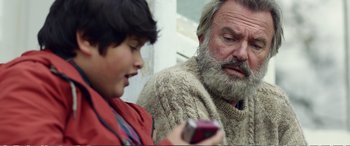 Movie still from “Hunt for the Wilderpeople” (2016), directed by Taika Waititi – An older man and a young boy looking at a cell phone; Close Up shot, Low angle