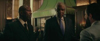 Movie still from “Hustle” (2022), directed by Jeremiah Zagar – A man in a suit and tie standing next to another man in a suit and tie; Medium shot, Low angle