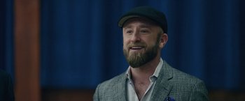 Movie still from “Hustle” (2022), directed by Jeremiah Zagar – A man with a goatee and beard wearing a hat; Close Up shot, Low angle