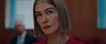 Movie still from “I Care a Lot” (2020), directed by J Blakeson – A person wearing a red shirt with blue eyes; Close Up shot, Low angle