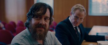 Movie still from “I Care a Lot” (2020), directed by J Blakeson – A man with a long beard and a man with a goatee; Close Up shot, Over the shoulder angle