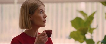 Movie still from “I Care a Lot” (2020), directed by J Blakeson – A beautiful woman holding a coffee cup in her hand; Close Up shot, Over the shoulder angle