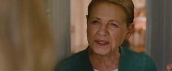Movie still from “I Care a Lot” (2020), directed by J Blakeson – An older woman with short blonde hair wearing a green shirt; Close Up shot, Over the shoulder angle
