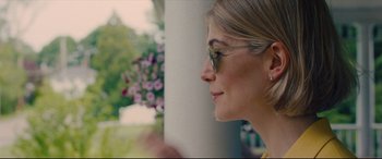 Movie still from “I Care a Lot” (2020), directed by J Blakeson – A person wearing glasses near a wall; Close Up shot, Over the shoulder angle