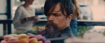 Movie still from “I Care a Lot” (2020), directed by J Blakeson – A man with long hair and a beard is looking at a plate of food; Close Up shot, Over the shoulder angle