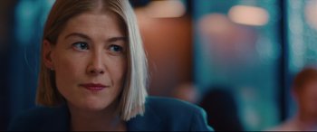 Movie still from “I Care a Lot” (2020), directed by J Blakeson – A woman's face in a blue jacket; Close Up shot, Over the shoulder angle