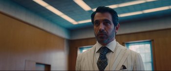 Movie still from “I Care a Lot” (2020), directed by J Blakeson – A person wearing a suit and a tie; Close Up shot, Over the shoulder angle