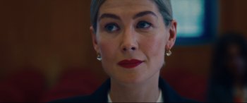 Movie still from “I Care a Lot” (2020), directed by J Blakeson – A person wearing a suit; Close Up shot, Over the shoulder angle