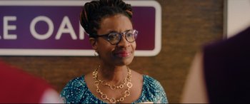 Movie still from “I Care a Lot” (2020), directed by J Blakeson – A woman wearing glasses and a blue dress; Close Up shot, Over the shoulder angle