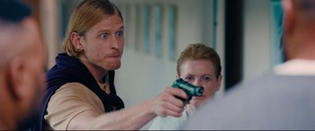 Movie still from “I Care a Lot” (2020), directed by J Blakeson – A man and a woman holding a gun in a room; Close Up shot, Over the shoulder angle