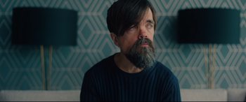 Movie still from “I Care a Lot” (2020), directed by J Blakeson – A man with long hair and a long beard; Close Up shot, High angle