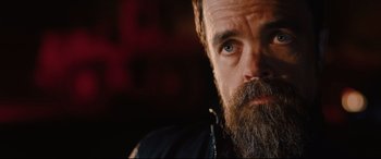 Movie still from “I Care a Lot” (2020), directed by J Blakeson – A person with a beard looking at the camera; Close Up shot, Low angle