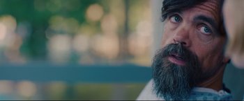 Movie still from “I Care a Lot” (2020), directed by J Blakeson – A man with a long beard is looking at the camera; Close Up shot, Over the shoulder angle