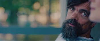 Movie still from “I Care a Lot” (2020), directed by J Blakeson – A man with a long beard is looking into the distance; Close Up shot, Over the shoulder angle