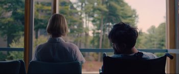 Movie still from “I Care a Lot” (2020), directed by J Blakeson – Two people sitting in a chair looking out a window; Medium shot, Over the shoulder angle