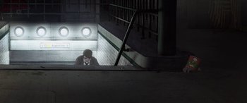 Movie still from “I Lost My Body” (2019), directed by Jérémy Clapin – A man sitting on a ledge in the dark; Wide shot, Overhead angle