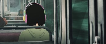 Movie still from “I Lost My Body” (2019), directed by Jérémy Clapin – A person wearing headphones on a public transit bus; Close Up shot, Overhead angle