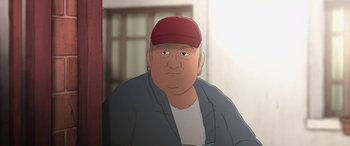 Movie still from “I Lost My Body” (2019), directed by Jérémy Clapin – An older man wearing a red hat and a white shirt; Close Up shot, Low angle