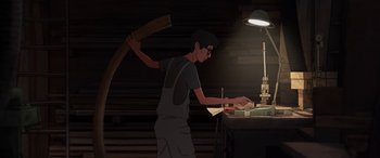 Movie still from “I Lost My Body” (2019), directed by Jérémy Clapin – A man holding an axe in his hand while standing in front of a table; Medium shot, Low angle