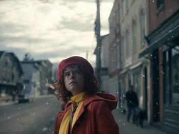 Movie still from “I'm Thinking of Ending Things” (2020), directed by Charlie Kaufman – A woman wearing a red coat and a red hat; Medium shot, Low angle