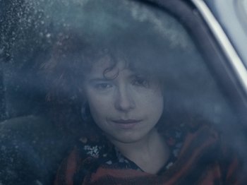 Movie still from “I'm Thinking of Ending Things” (2020), directed by Charlie Kaufman – A woman with curly red hair sitting in a car; Close Up shot, Over the shoulder angle