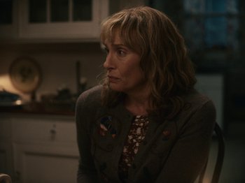 Movie still from “I'm Thinking of Ending Things” (2020), directed by Charlie Kaufman – A woman sitting in front of a kitchen counter; Close Up shot, Over the shoulder angle