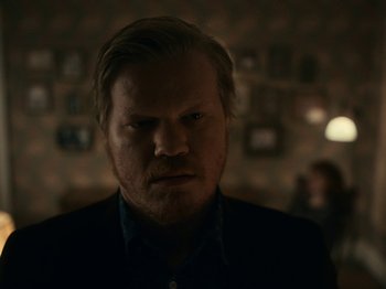 Movie still from “I'm Thinking of Ending Things” (2020), directed by Charlie Kaufman – A person in a dark room; Close Up shot, Over the shoulder angle