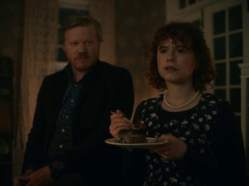 Movie still from “I'm Thinking of Ending Things” (2020), directed by Charlie Kaufman – A man and a woman standing next to each other holding plates of food; Medium shot, Over the shoulder angle