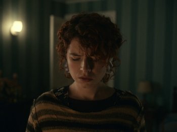 Movie still from “I'm Thinking of Ending Things” (2020), directed by Charlie Kaufman – A woman with curly red hair is looking down; Close Up shot, Over the shoulder angle
