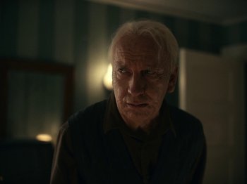 Movie still from “I'm Thinking of Ending Things” (2020), directed by Charlie Kaufman – An old man with white hair stares into the camera; Close Up shot, Low angle