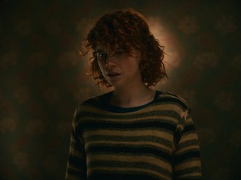 Movie still from “I'm Thinking of Ending Things” (2020), directed by Charlie Kaufman – A woman with red hair and a striped sweater; Close Up shot, High angle