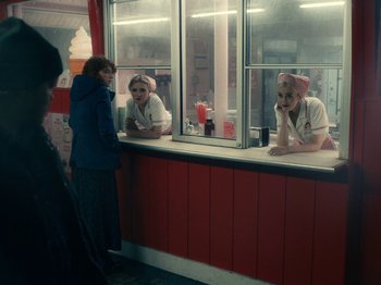 Movie still from “I'm Thinking of Ending Things” (2020), directed by Charlie Kaufman – Two women are looking in the mirror at a diner; Medium shot, Over the shoulder angle