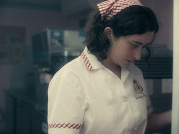 Movie still from “I'm Thinking of Ending Things” (2020), directed by Charlie Kaufman – A woman wearing a white shirt and a red and white headband; Medium shot, Low angle
