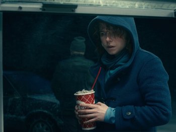 Movie still from “I'm Thinking of Ending Things” (2020), directed by Charlie Kaufman – A person holding a cup of coffee in front of a car window; Medium shot, Over the shoulder angle