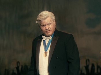 Movie still from “I'm Thinking of Ending Things” (2020), directed by Charlie Kaufman – A man in a tuxedo with a medal around his neck; Close Up shot, High angle