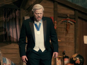 Movie still from “I'm Thinking of Ending Things” (2020), directed by Charlie Kaufman – A man in a tuxedo with a medal around his neck; Medium shot, High angle