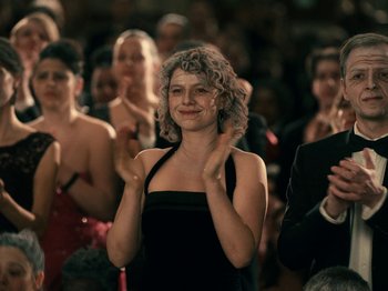 Movie still from “I'm Thinking of Ending Things” (2020), directed by Charlie Kaufman – A group of people standing in front of each other clapping; Medium shot, Over the shoulder angle