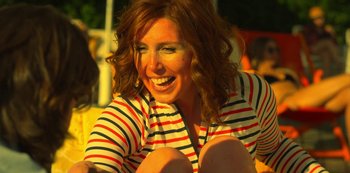 A woman sitting on the ground smiling for the camera