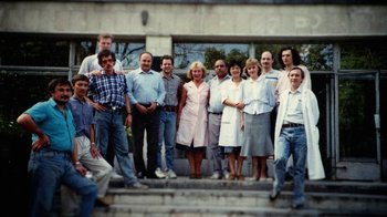 Movie still from “Icarus” (2017), directed by Bryan Fogel – A group of men and women standing in front of a building; Wide shot, High angle