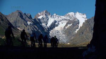 Movie still from “Icarus” (2017), directed by Bryan Fogel – A group of people riding bikes in front of a snowy mountain; Extreme Wide shot, Low angle