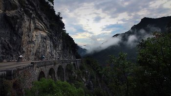 Movie still from “Icarus” (2017), directed by Bryan Fogel – A view of a bridge that is on the side of a mountain; Extreme Wide shot, Low angle
