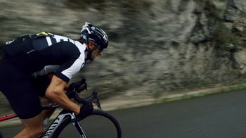 Movie still from “Icarus” (2017), directed by Bryan Fogel – A man riding a bike down a street; Wide shot, High angle