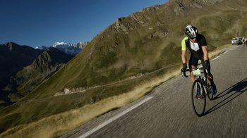 Movie still from “Icarus” (2017), directed by Bryan Fogel – A man riding a bike down the side of a road; Extreme Wide shot, Low angle
