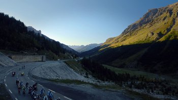 Movie still from “Icarus” (2017), directed by Bryan Fogel – A group of people riding bikes on a mountain side; Extreme Wide shot, High angle
