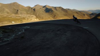 Movie still from “Icarus” (2017), directed by Bryan Fogel – A person riding a bike on top of a dirt hill; Extreme Wide shot, High angle