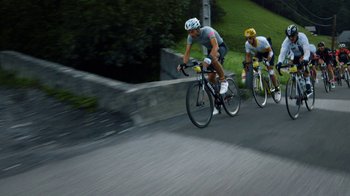 Movie still from “Icarus” (2017), directed by Bryan Fogel – Two men are riding their bikes down a hill; Wide shot, Low angle